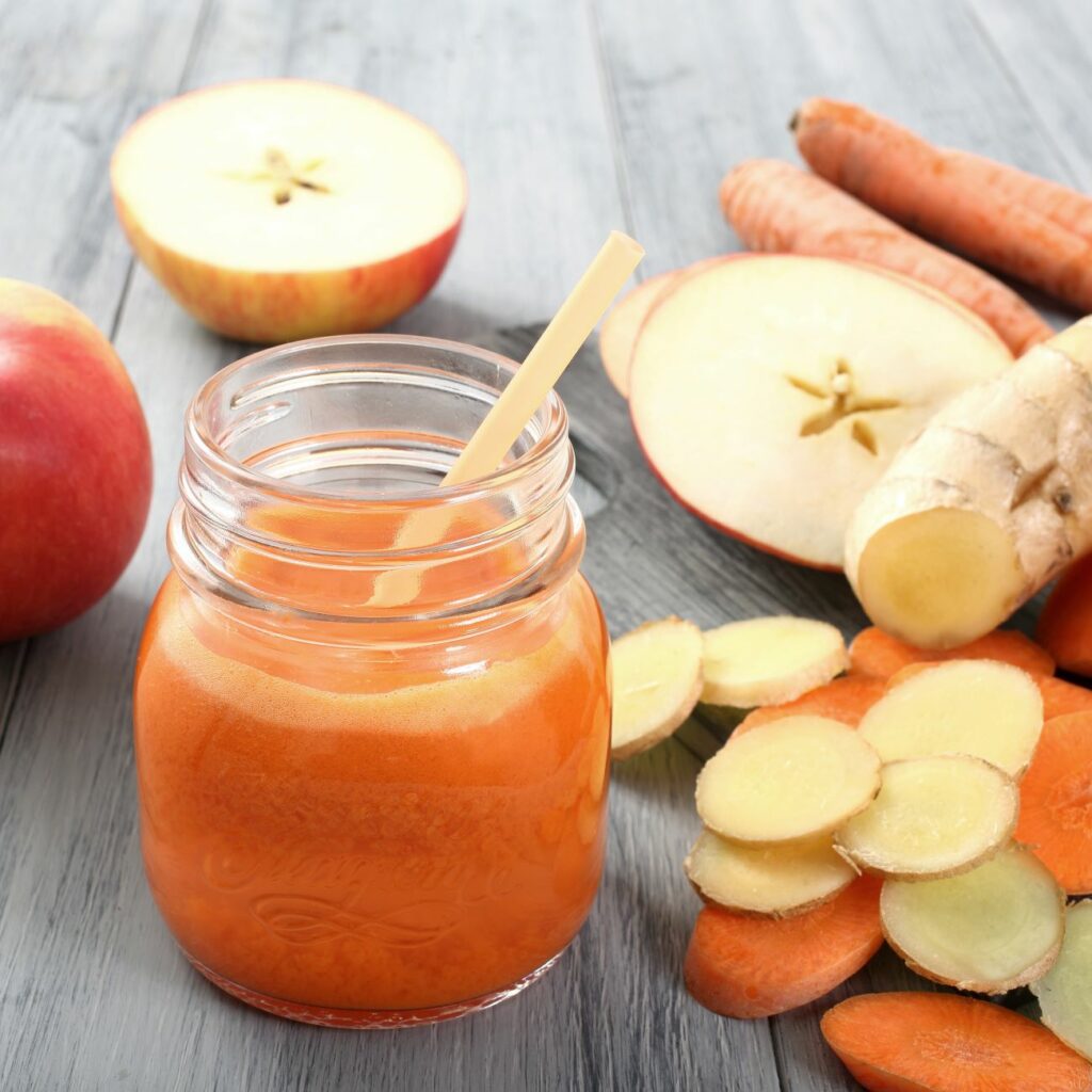 Frischer ACE-Saft wird mit Strohhalm in einem Einmachglas serviert und mit Äpfeln dekoriert.