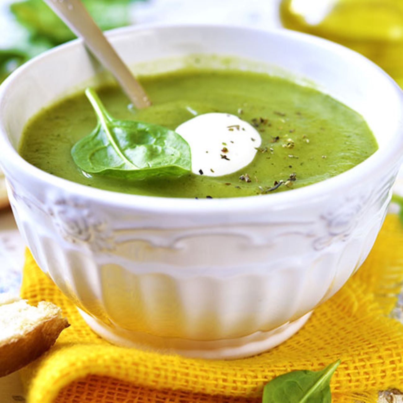 Brokkoli-Spinat-Suppe wird dekoriert mit Brokkoli in einer weißen Schale serviert