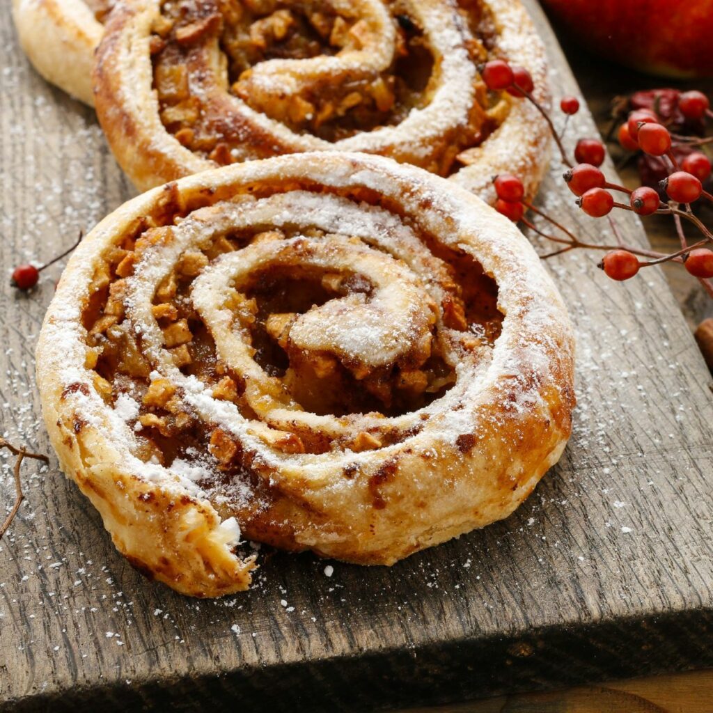 Vollkorn Zimtschnecken werden auf einem Holzbrett serviert.