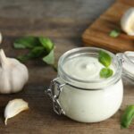 Vegane Knoblauch-Sauce wird in einem kleinen Einmachglas gezeigt.