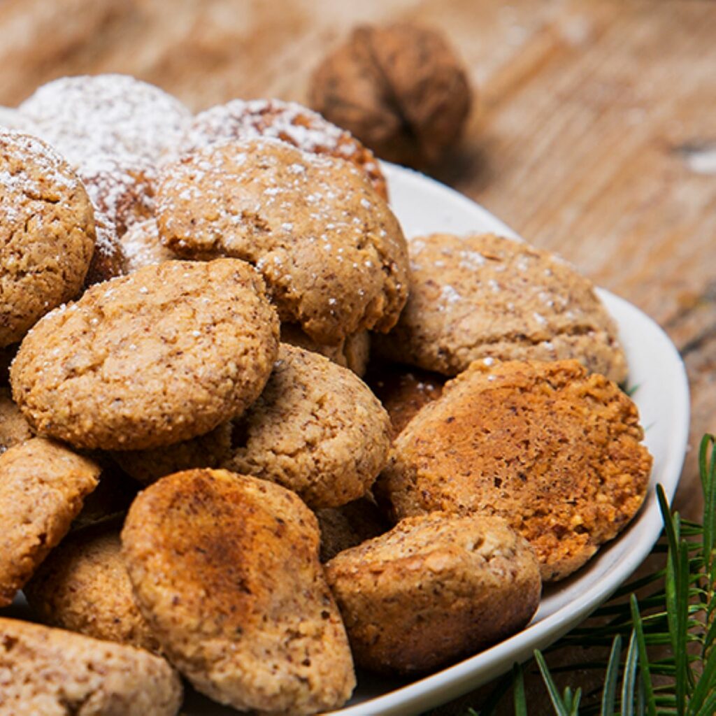 Vegane Mandelplätzchen werden nah in einer weißen Schüssel gezeigt.