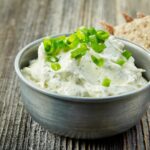 Wasabi-Dip wird getoppt mit Frühlingszwiebeln gezeigt.