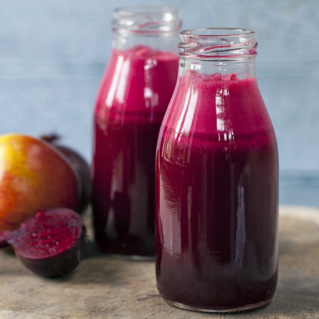 Rote Bete Saft wird in zwei kleinen Glasflaschen präsentiert.