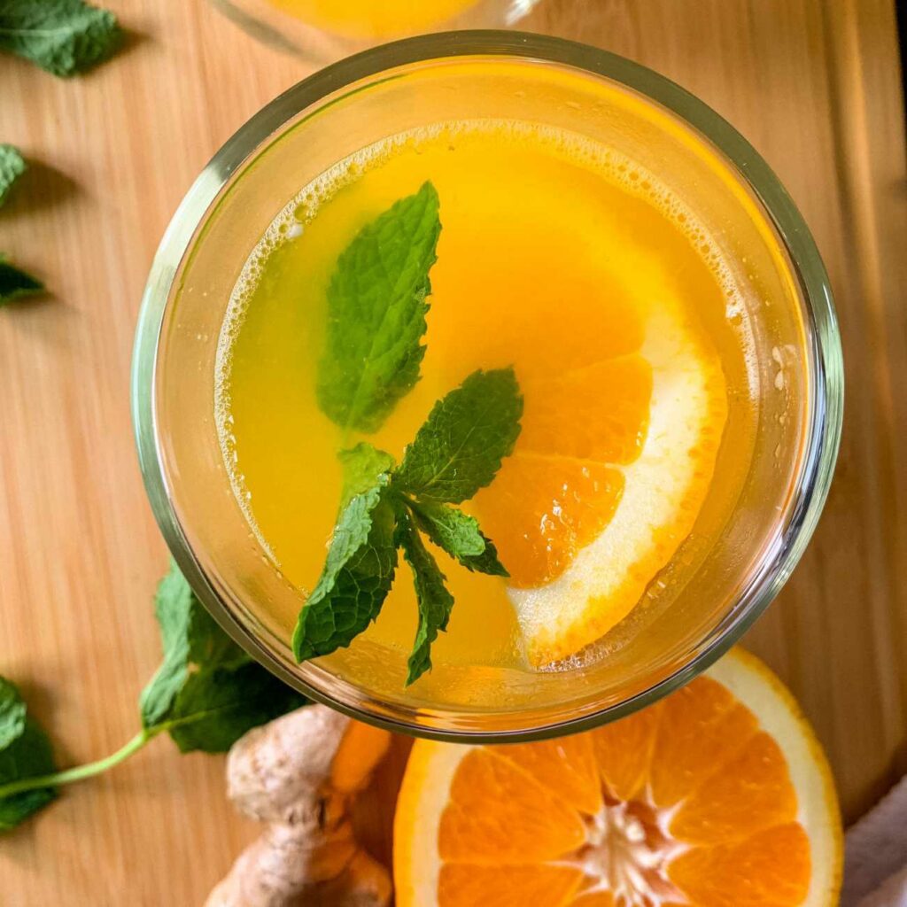 Zázvorový a pomerančový čaj je zobrazen v čajové sklenici shora.