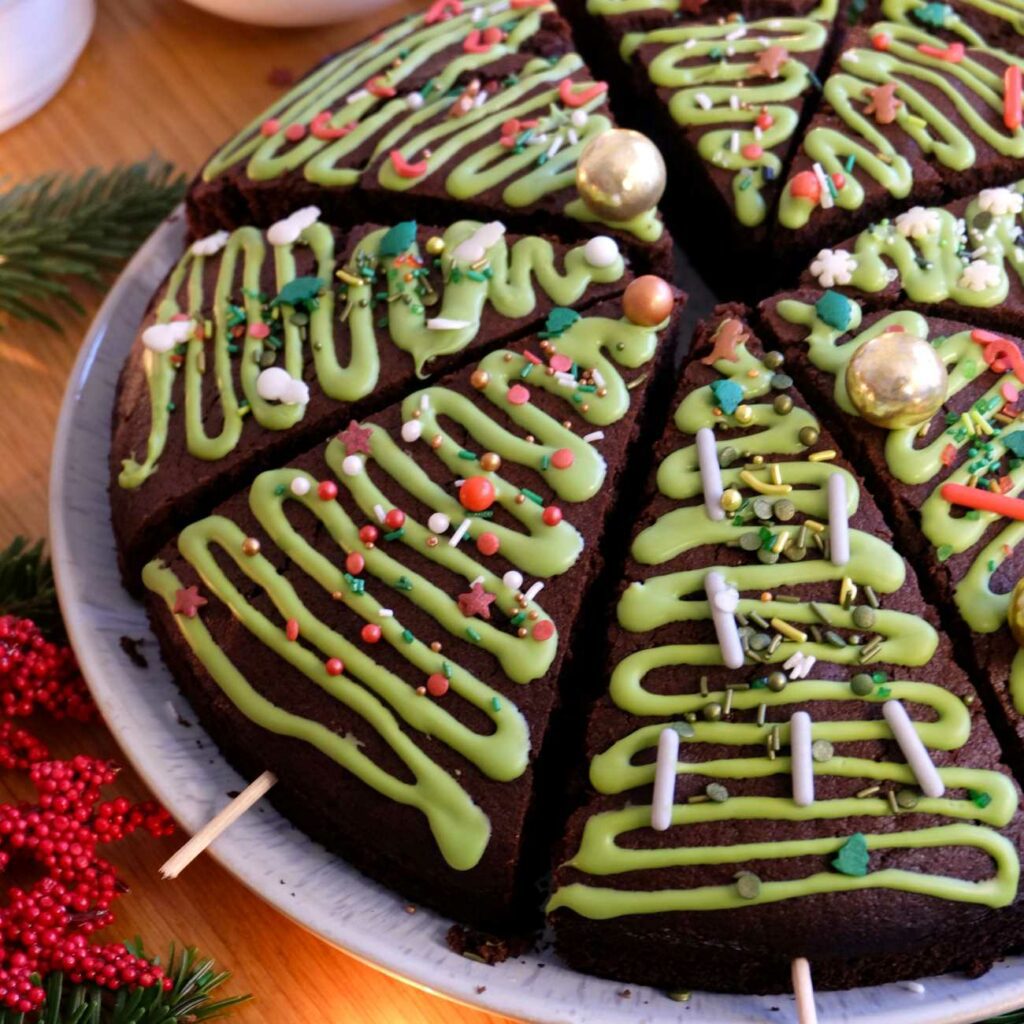Gewürzkuchen wird mit weihnachtlicher Verzierung in Stücke geschnitten gezeigt.