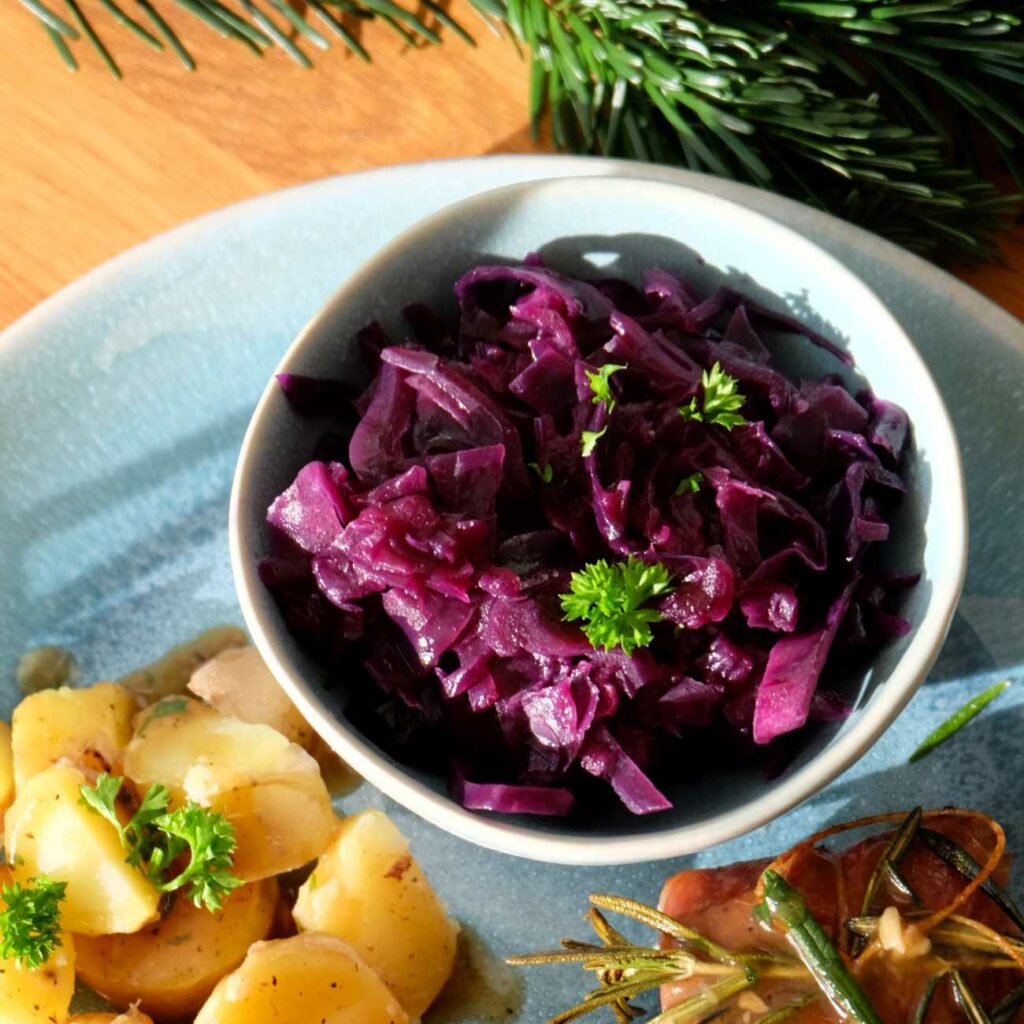 Rotkohl wird in einer kleinen Schale auf einem angerichteten Teller gezeigt.
