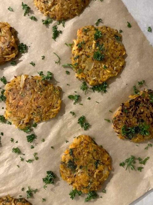 Süßkartoffelpuffer werden auf Backpapier ausgelegt gezeigt. 