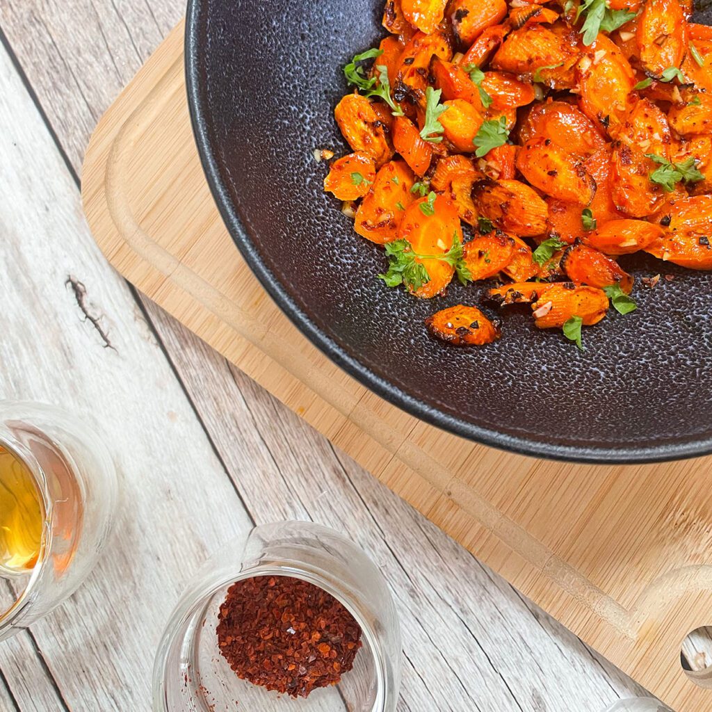 Karotten aus der Heißluftfritteuse werden in einer schwarzen Schüssel gezeigt.